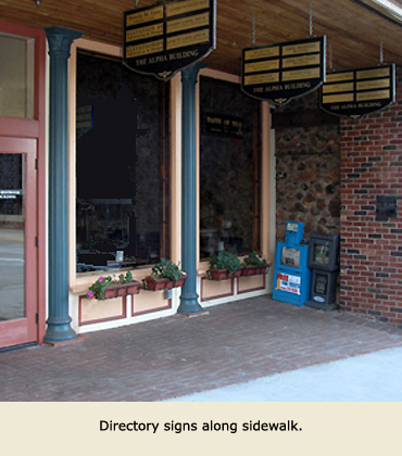 Alpha Building directory signs along sidewalk.