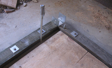 Metal column bases and wooden 3x6 sill plates.