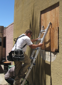 Plywood is removed from windows in the private alley.