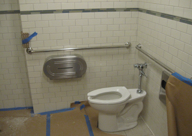 Stainless steel and chrome accessories installed in a restroom.