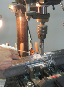 Water-based coolant is sprayed on a drill bit.