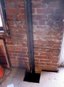 A steel column installed through the floor, down to the concrete foundation.