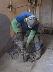 Part of a concrete slab is removed to make room for a new concrete foundation that will hold up a steel I-Beam moment frame.