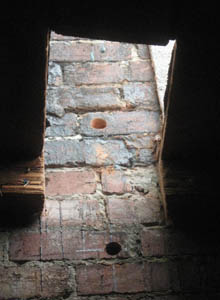 A removed section of roof and a line of drilled holes to allow the installation of epoxied all-thread rods.
