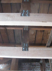 Steel plates and thick-shank wood screws are used to connect new lumber to old.