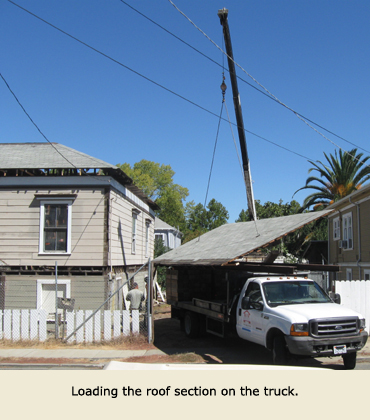 A Trost Jacking & Heavy Moving crane places a piece of the roof on a Trost truck as a part of the house move.