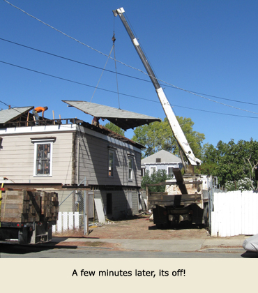 Section of roof being lifted as a part of moving the house.