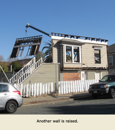 A section of wall is raised by a Trost crane, as part of moving the house.