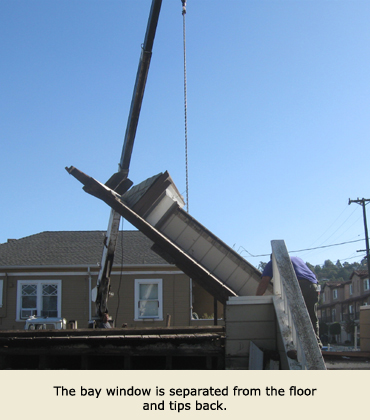 The crane from Trost Jacking of Concord, CA, tips back the bay window during the house moving process.