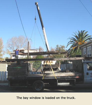 The bay window is loaded on a Trost house movers truck.