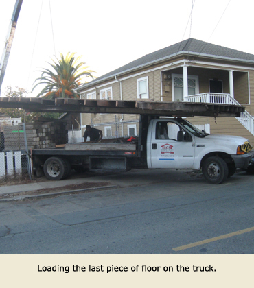 The last section of the house move is loaded on a Trost truck.